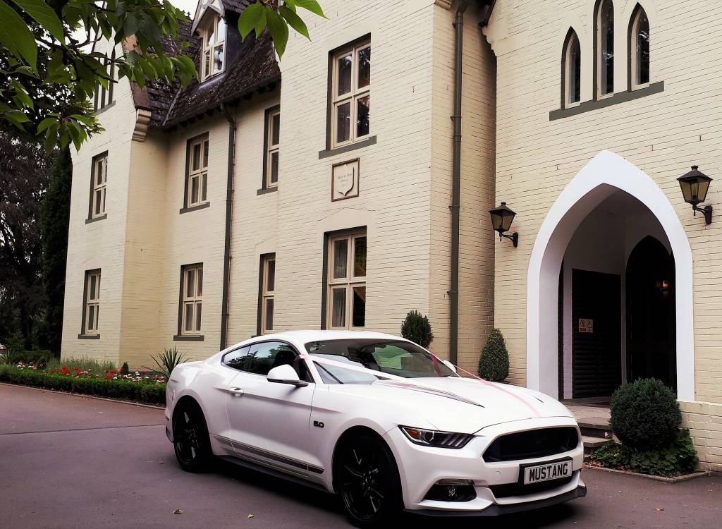 Image of 2018 white Ford Mustang outside the front of the Glen-Yr-Afon
