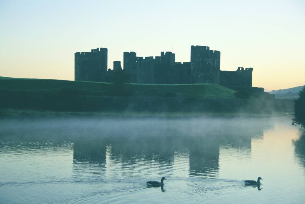 A view over the lake surrounding Caerphilly Castle on a misty morning.© Crown copyright 2018 (Visit Wales)